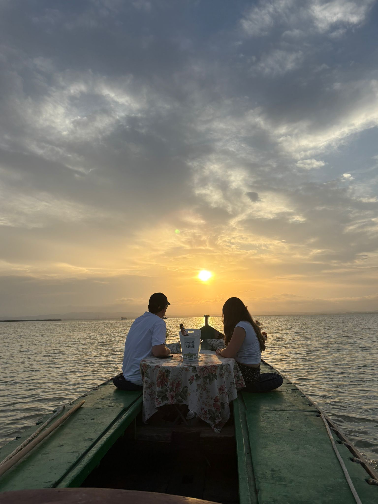 Pareja viendo la puesta de sol en barca
